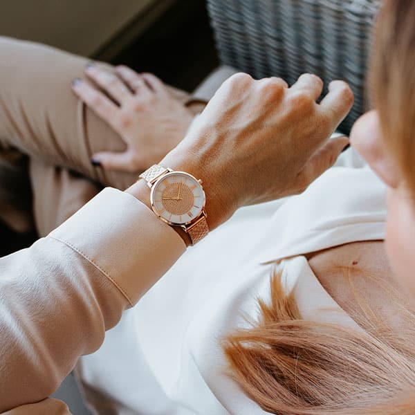 Frau schaut auf Armbanduhr