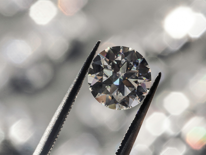 Lab-Grown Diamant mit einer Pinzette gehalten