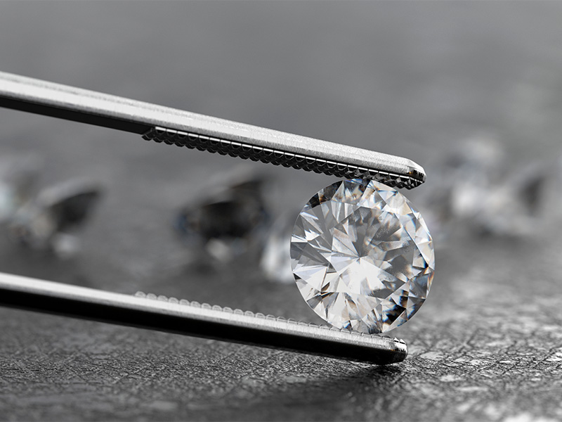 Lab-Grown Diamant mit einer Pinzette gehalten