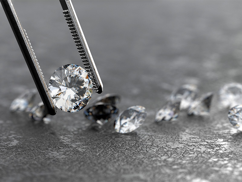 Lab-Grown Diamant mit einer Pinzette gehalten