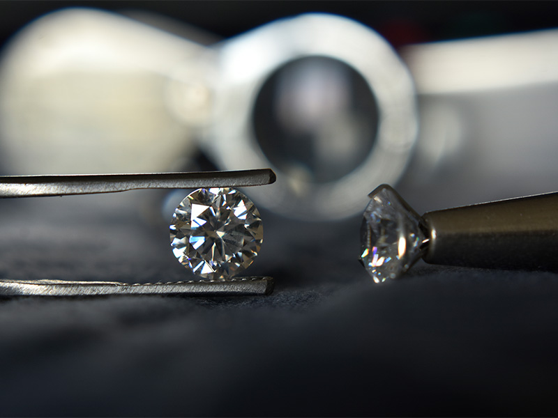 Lab-Grown Diamant mit einer Pinzette gehalten