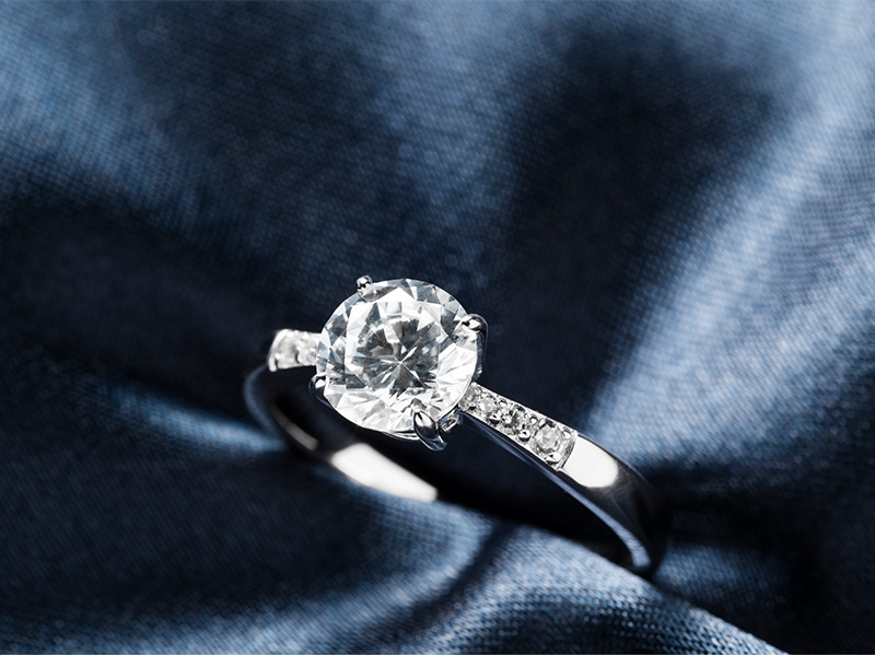 Lab-Grown Diamanten Ring, gehalten in blauer Seide